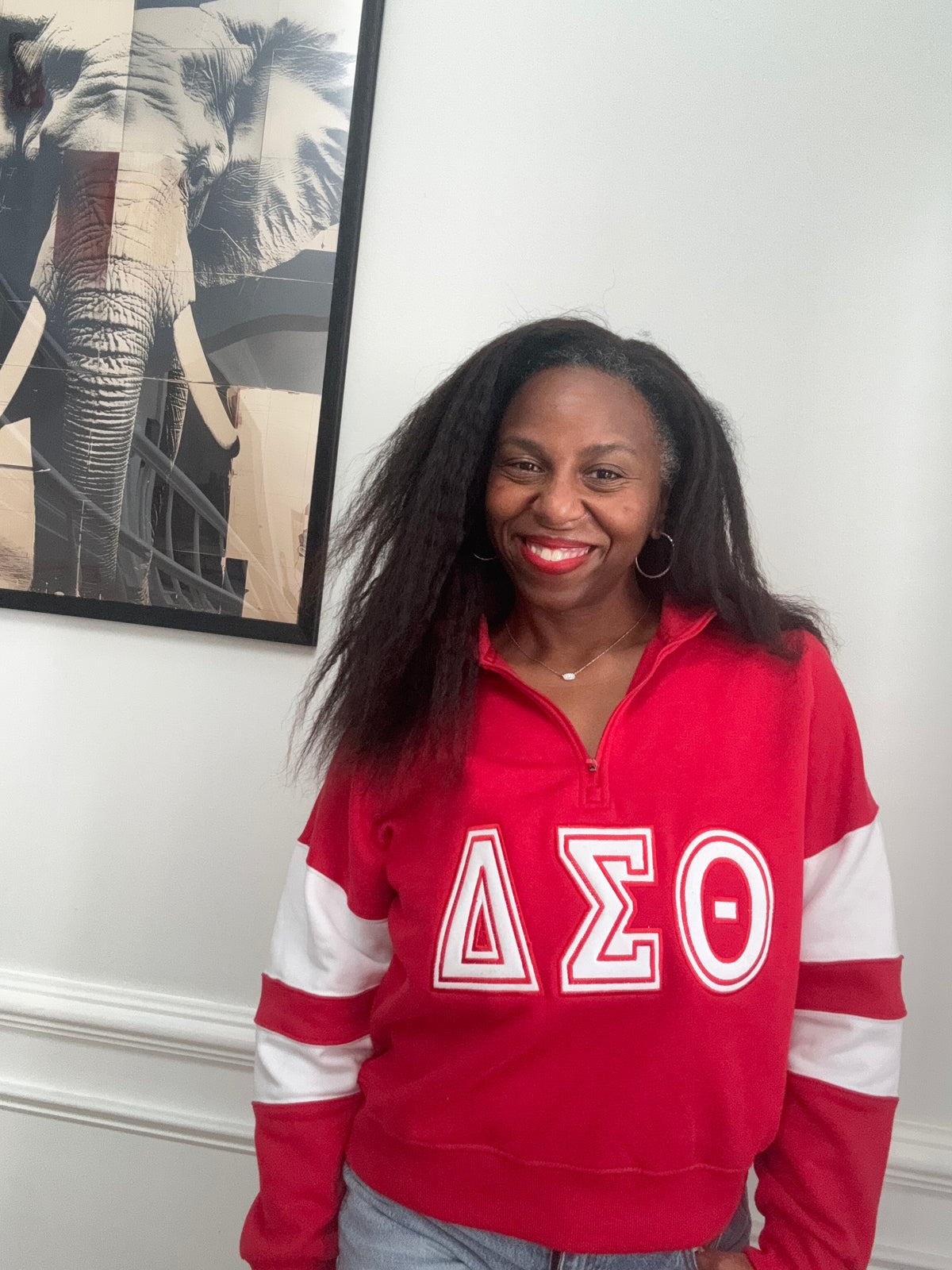 Model wearing red and white Delta Sigma Theta cropped pullover with high-waisted denim
