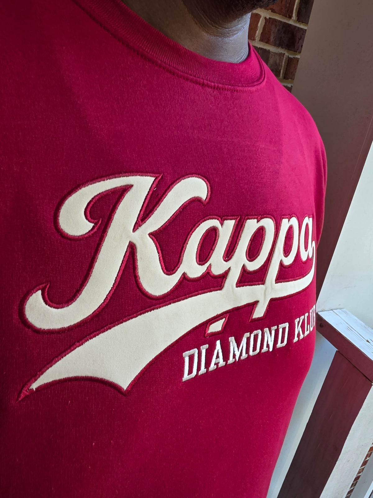 Close-up view of raised satin stitch Diamond Klub embroidery on Kappa Alpha Psi red sweatshirt