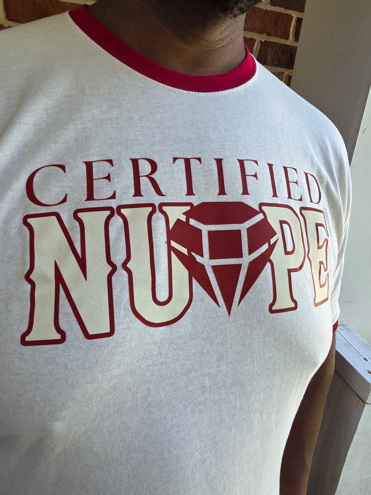 Close-up of Certified Nupe graphic print on cream cotton ringer tee shirt