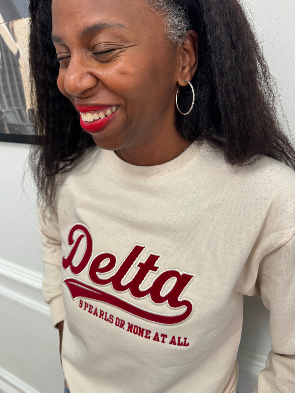 Model wearing Delta Sigma Theta 9 Pearls or None at All crewneck sweatshirt with dark jeans